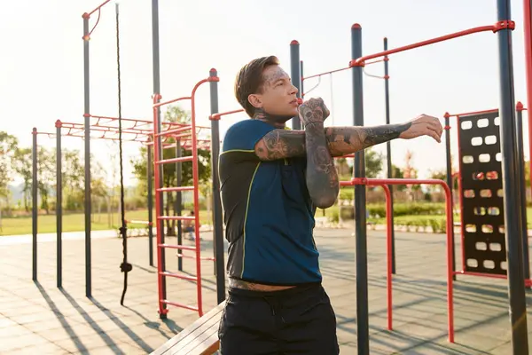 Göz alıcı genç bir adam hareketli oyun bahçesinde aktif bir güne hazır bir şekilde esniyor..