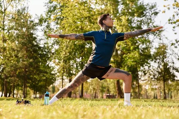 Genç adam, güneşin ve doğanın sıcaklığını kucaklayarak canlı bir parkta geziniyor..