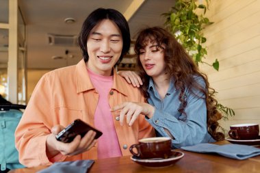 İki genç arkadaş, canlı bir kafede kahkahalarla kahkahalarla kahkahalarla kahkaha atar..