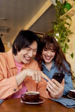 İki genç arkadaş bir fincan kahve eşliğinde kahkahalarımızı paylaşırken birbirlerinin arkadaşlıklarından hoşlanırlar..