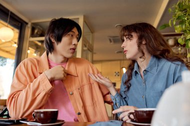 İki genç arkadaş keyifli bir sohbeti canlı bir kafede kahve içerek paylaşıyorlar..