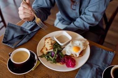 Kadın canlı bir kafede brunch yapıyor, hafta sonları yemek yiyor.
