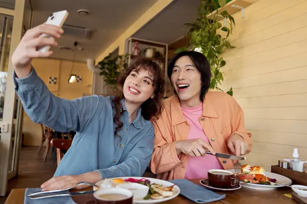 İki çok kültürlü arkadaş birlikte selfie çekerken keyifli bir brunch 'ın tadını çıkarıyorlar..