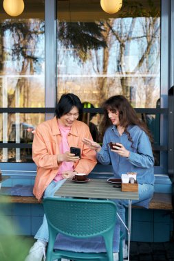 İki arkadaş kahve içerken, kahkahalar atarken ve bir kafede hikayeler anlatırken birlikte vakit geçirmekten zevk alırlar..