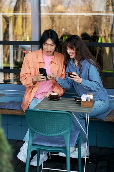 Genç çok kültürlü arkadaşlar bir kafede rahatlar, kahkahalarını paylaşır ve birlikte içkilerinin tadını çıkarırlar..