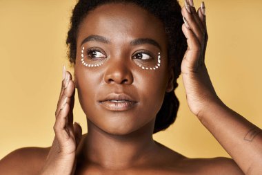 Genç bir kadın, güzellik rutiniyle uğraşırken taze ve parlak tenini sergiliyor..