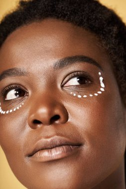 Genç bir Afrikalı Amerikalı kadın stüdyoda cildine odaklanırken güzel tenini sergiliyor..