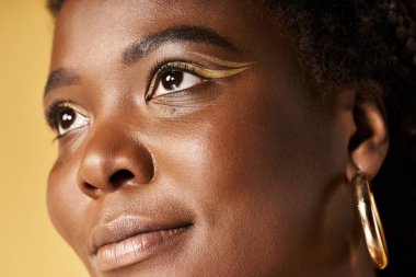 Genç bir Afrikalı Amerikalı kadın güzel tenini parlak bir stüdyoda sergiliyor..