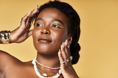 Genç siyahi bir kadın parlak cildini ve özgüvenini parlak bir stüdyoda sergiliyor..