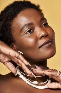 Genç bir Afrikalı Amerikalı kadın zarafetle poz verirken parlak tenini sergiliyor..