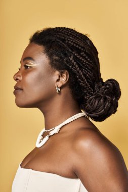 Genç Afrikalı Amerikalı kadın canlı bir stüdyo ortamında parlak ten ve güzellik sergiliyor..