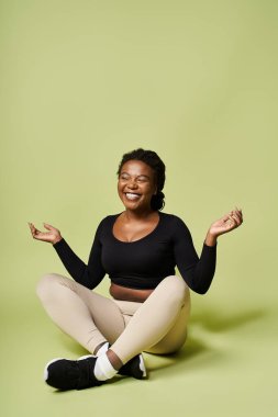 Parlak bir stüdyoda, Afrikalı Amerikalı genç bir kadın enerjik bir fitness seansının keyfini çıkarıyor..