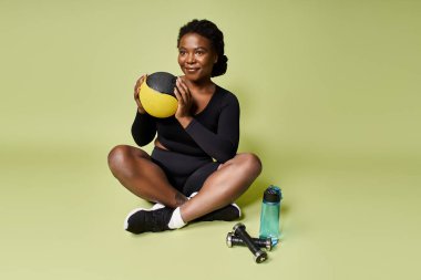 Genç ve formda bir Afro-Amerikan sporcu, canlı bir stüdyoda otururken antrenmanına odaklanıyor..