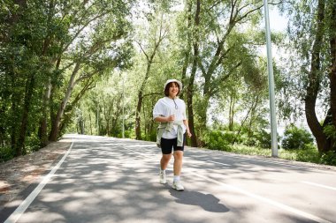 Yeşilliğin ortasında koşan genç bir kadın, açık havada spor yapmayı kucaklıyor..