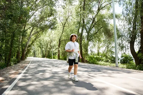 Yeşilliğin ortasında koşan genç bir kadın, açık havada spor yapmayı kucaklıyor..