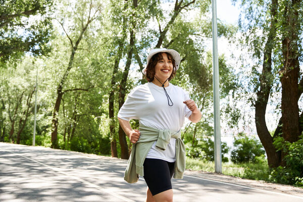 Young woman enjoys her outdoor workout, jogging surrounded by vibrant greenery and sunshine.