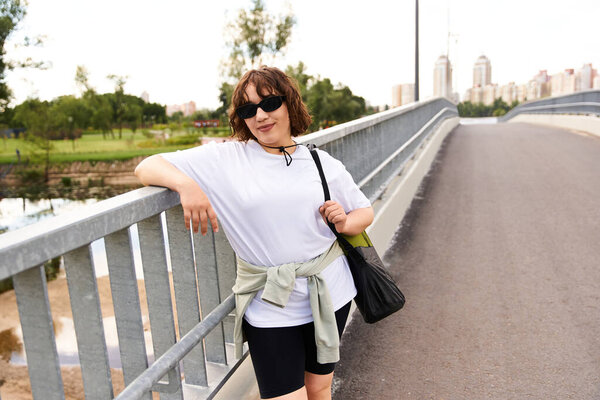 A young woman embraces her fitness journey while exercising outdoors near a scenic river.