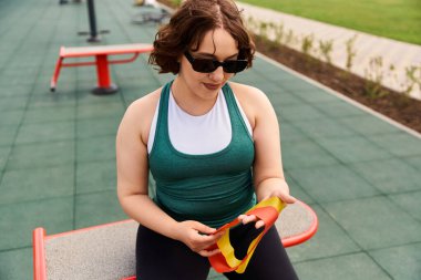 Formda genç bir kadın güneşli bir spor salonunda egzersiz yapmaya hazırlanıyor..