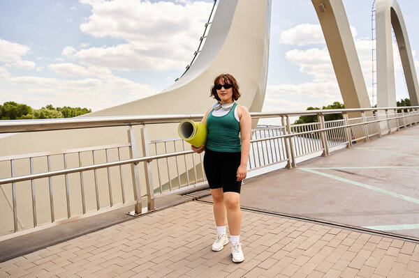 Женщина тренируется на открытом воздухе, демонстрируя силу и стиль в оживленной обстановке.