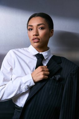 Zarif genç bayan kendine güvenen bir şekilde özel dikim bir takım elbiseyle poz veriyor..