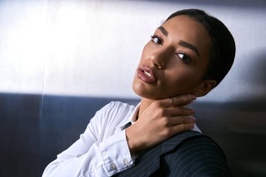 Çekici genç kadın, şık tarzını şehirde çarpıcı bir çağdaş arka plana vurguluyor..