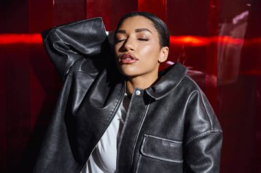 Şık giyinmiş zarif bir kadın şık tarzını sergileyerek kendine güvenerek poz veriyor..