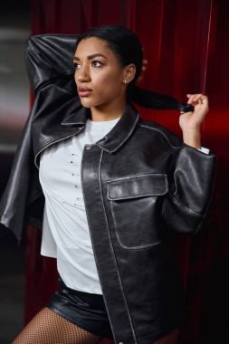 Güzel, genç bir kadın şık bir şekilde poz verir, kendine güveni ve tarzı vardır..