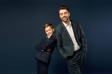 Bir baba ve oğul gururla bir anı paylaşır, şenlikli bir kutlama için şık giyinirler..