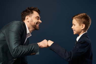 2025 Babalar Günü 'nde bir baba ve oğul, sevgi ve bağlarını yansıtan neşeli bir yumruk tokuşturur..