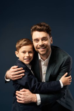 Neşeli bir baba ve oğul kucaklaşır, kalpten bir kutlama sırasında sevgi ve beraberlik gösterir..