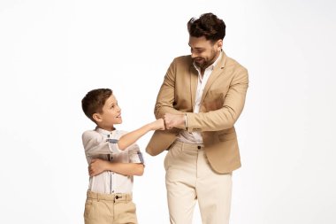 Bir baba ve oğul neşeli bir anı paylaşır, kutlama sırasında gülümseyerek yumruk tokuştururlar..