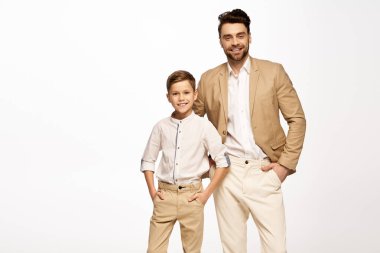 Baba ve oğul, şenlikli bir kutlama için şık bir şekilde giyinmiş bir şekilde gülümsüyor..