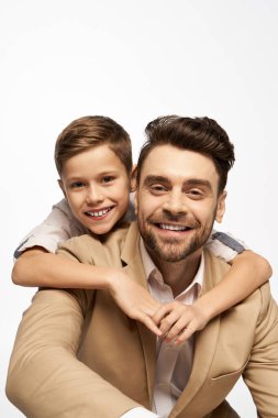 Neşeli bir baba ve oğul kucaklaşır, birbirlerine sevgilerini ve mutluluklarını gösterirler..