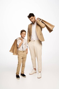 Baba ve oğul birlikte özel bir kutlama için şık giyinmiş neşeli bir anı paylaşıyorlar..