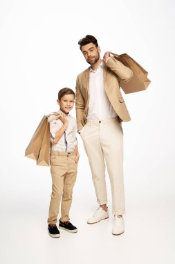 Baba ve oğul birlikte bir şenlik anı paylaşıyor, kutlama sırasında sevgi ve tarz sergiliyorlar..