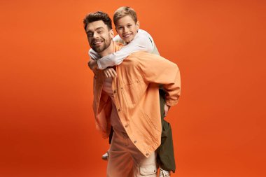 Neşeli bir baba, Anılar Günü 'nde oğlunu sırtında taşır ve kahkahalar atar..