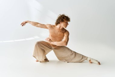 Kıvırcık saçlı genç bir adam dans yeteneklerini enerji dolu bir stüdyoda sergiliyor..