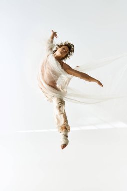 Genç bir adam stüdyoda zarif bir şekilde dans ediyor..