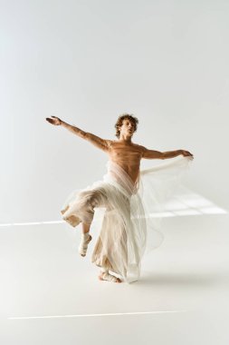 Genç kıvırcık saçlı bir adam dans yeteneklerini parlak bir stüdyoda sergiliyor, neşe ve hareketi ifade ediyor..