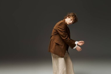 Kıvırcık saçlı genç bir adam zarif bir stüdyoda atletizmini sergiliyor..