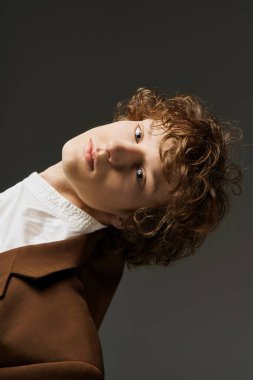 Kıvırcık saçlı genç bir adam stüdyoda dans ederken hareket ve tutku ifade eder..