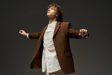 Genç, kıvırcık bir adam, gösterişli bir stüdyoda, tutkusunu sergileyerek dinamik bir dans gösterisi yapıyor..