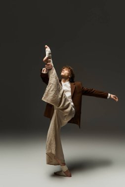 Kıvırcık saçlı genç bir adam dans yeteneklerini stüdyoda sergiliyor, yaratıcılık ve tutku yayıyor..