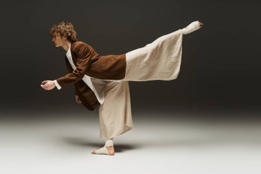 Minimalist bir stüdyoda, genç bir kıvırcık dansçı zarif bir kontrolle akışkan hareketler sergiliyor..