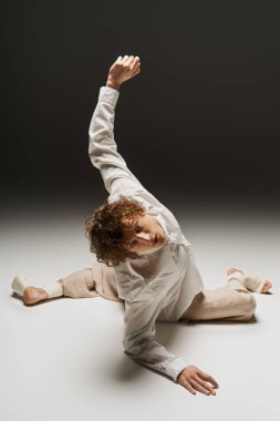 Genç bir kıvırcık dansçı atletizmini modern bir stüdyoda dinamik hareketlerle sergiliyor..