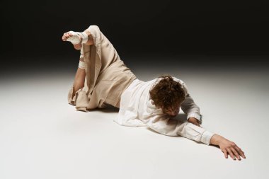 Genç bir dansçı, atletizm ve sanatın altını çizerek stüdyo zemininde zarifçe hareket eder..