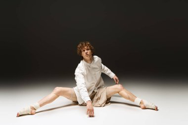 Kıvırcık saçlı dansçı stüdyoda atletizm ve tutku sergiliyor..