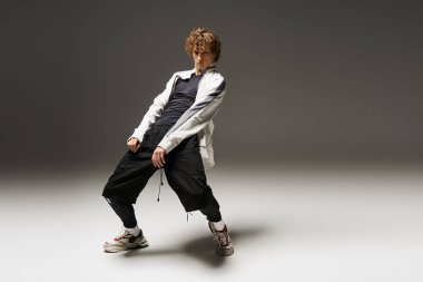 Genç kıvırcık saçlı bir dansçı tutkusunu stüdyo ortamında hareket ederek ifade eder..