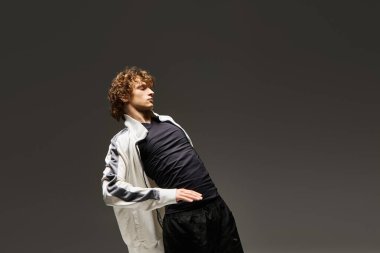 Kıvırcık saçlı dansçı şık stüdyo ortamında zarif hareketlerle büyülenir..