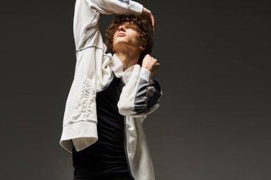 Genç adam dinamik dans figürlerini modern stüdyo ortamında sergiliyor..